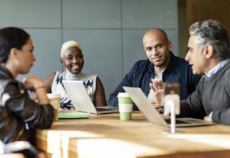 Team sat around a table having a meeting 