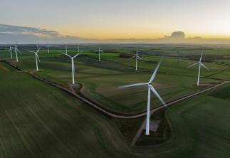 Wind Turbines In A Field with Sunset in background