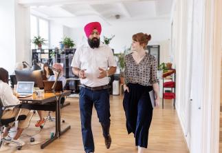 Colleagues walking together having a chat in office environment