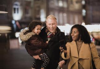 Couple walking with dad carrying child all in their coats