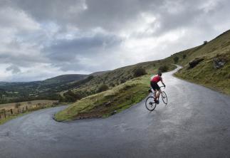 Cycling up mountain road with stormy skies