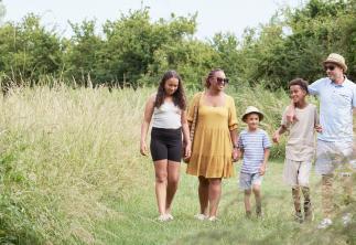 Family walking in summer outfits in a field