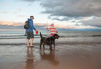 Two people in the sea with their dog