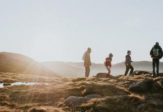 family on a country walk on hills with sunset in background