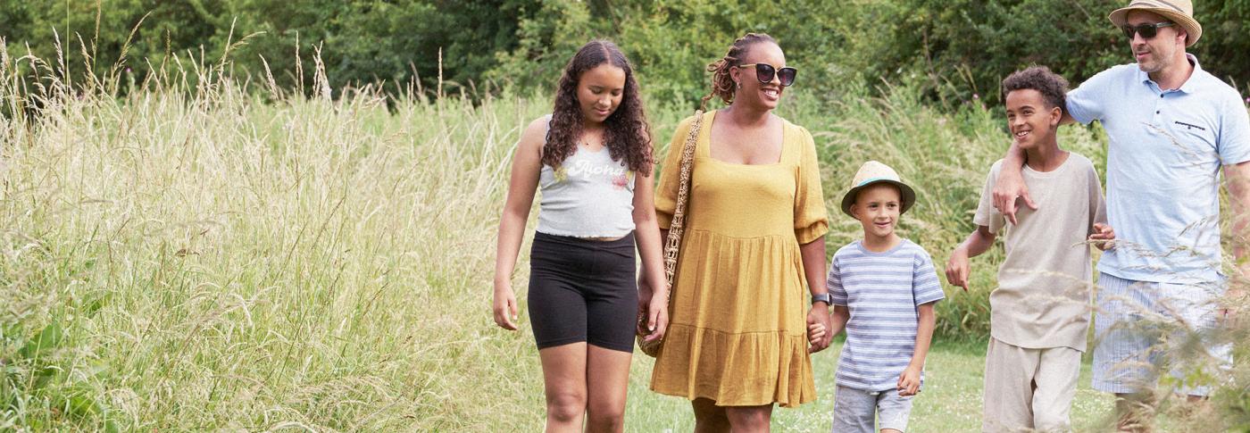 Family walking in summer outfits in a field