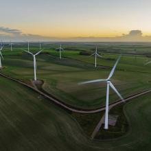 Wind Turbines In A Field with Sunset in background