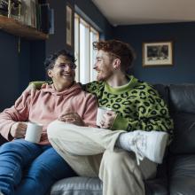 Couple sat on sofa in their home