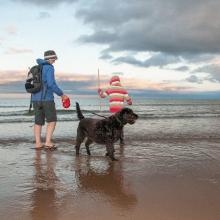 Two people in the sea with their dog