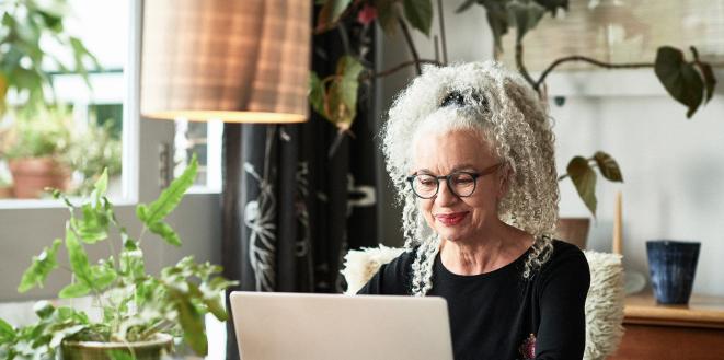 Lady on her laptop working with lots of green plants around her