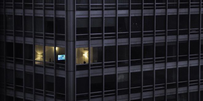 Office block with all lights off apart from one office