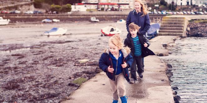 Children running on bridge by water