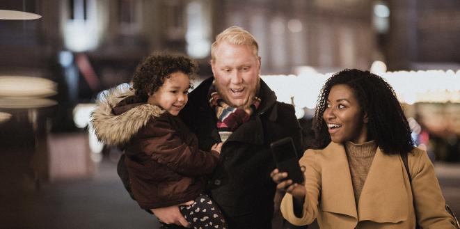 Couple walking with dad carrying child all in their coats