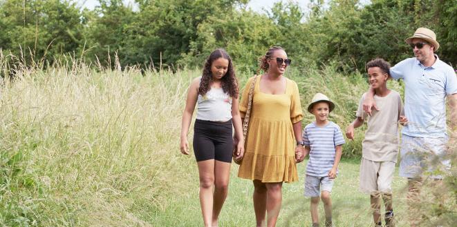 Family walking in summer outfits in a field