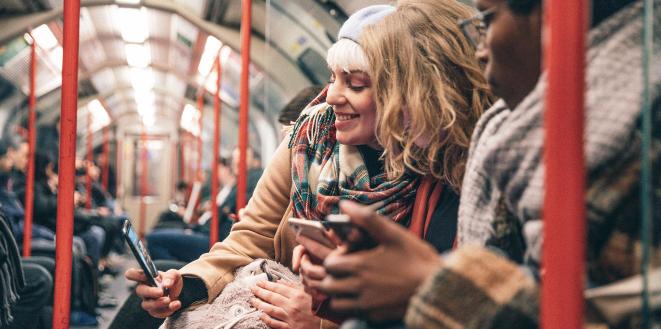 Group of people on bus looking at mobile phones