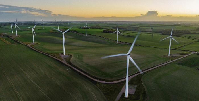 Wind Turbines In A Field with Sunset in background