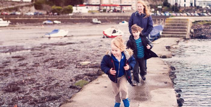 Children running on bridge by water