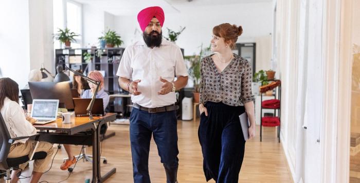 Colleagues walking together having a chat in office environment