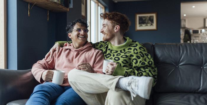 Couple sat on sofa in their home