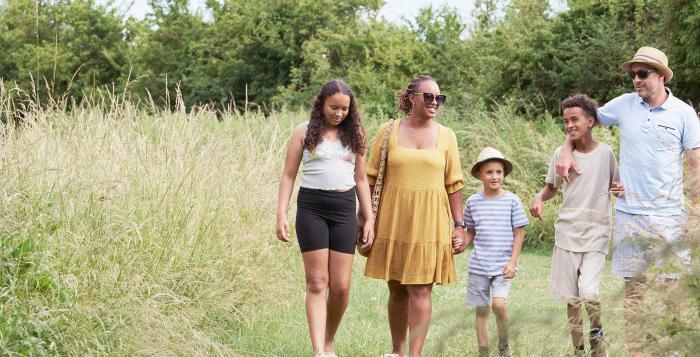 Family walking in summer outfits in a field