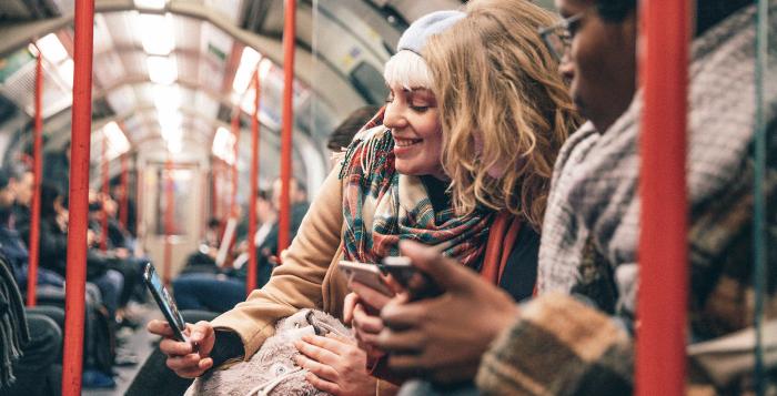 Group of people on bus looking at mobile phones