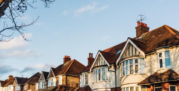 Image of houses with sun setting on them