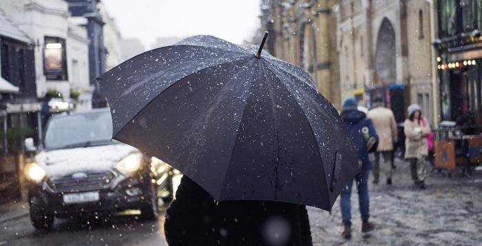 Person walking in the rain with umbrella