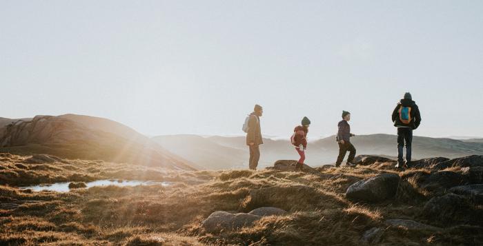 family on a country walk on hills with sunset in background