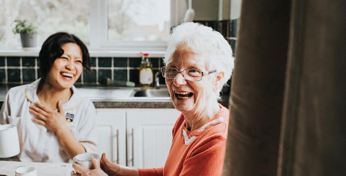 ladies sat in their kitchen looking happy and smiling